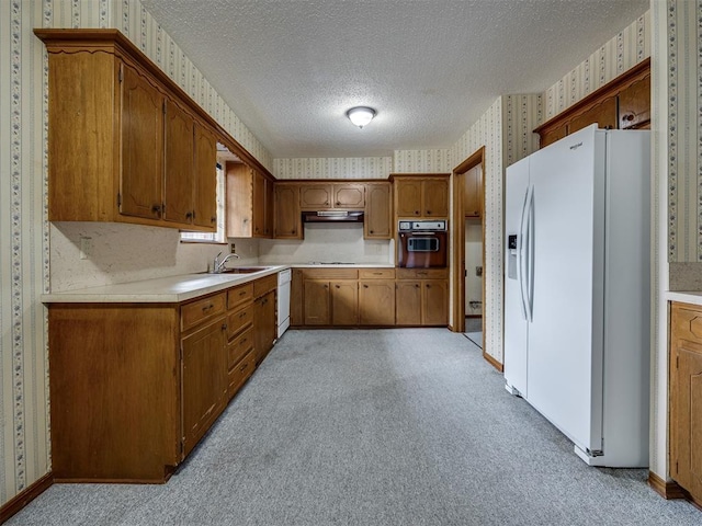 4004 N Shannon Ave, Bethany, OK 73008 - kitchen with wallpapered walls, white appliances, light countertops, a textured ceiling, and brown cabinets