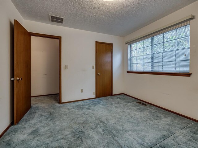 4004 N Shannon Ave, Bethany, OK 73008 - unfurnished bedroom featuring carpet floors, a textured ceiling, a closet, and baseboards