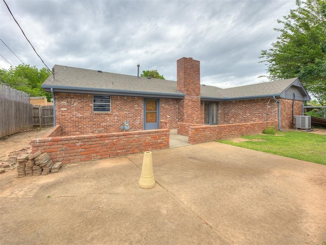 4004 N Shannon Ave, Bethany, OK 73008 - back of house featuring brick siding, a chimney, roof with shingles, and a patio area
