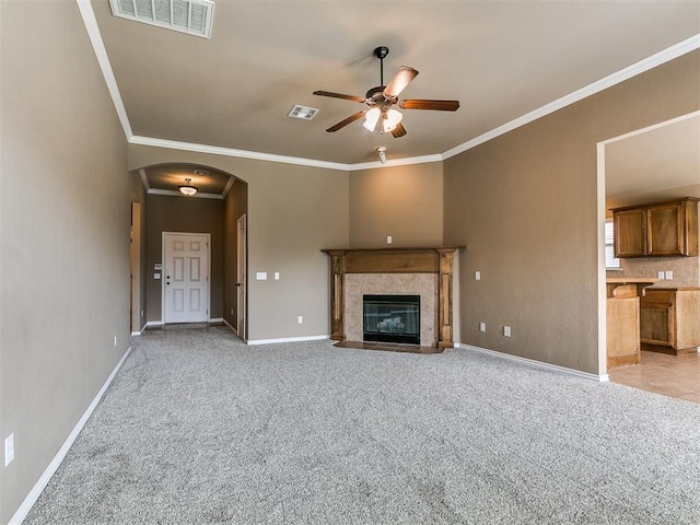 7909 Dawn Cir, Oklahoma City, OK 73135 - unfurnished living room featuring a ceiling fan, arched walkways, light carpet, crown molding, and baseboards