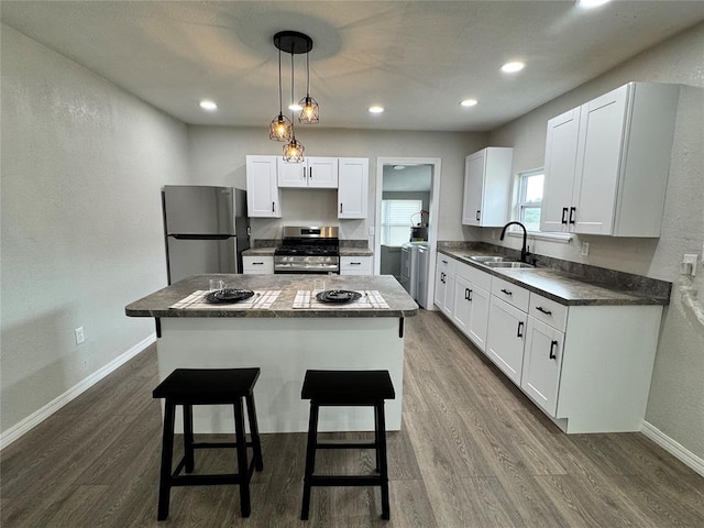 214 N 3rd St, Sentinel, OK 73664 - kitchen featuring appliances with stainless steel finishes, a sink, independent washer and dryer, dark wood-type flooring, and white cabinets
