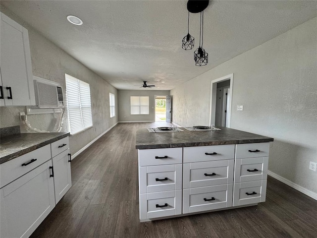 214 N 3rd St, Sentinel, OK 73664 - kitchen featuring dark countertops, ceiling fan, dark wood-style flooring, a textured ceiling, and a wall unit AC