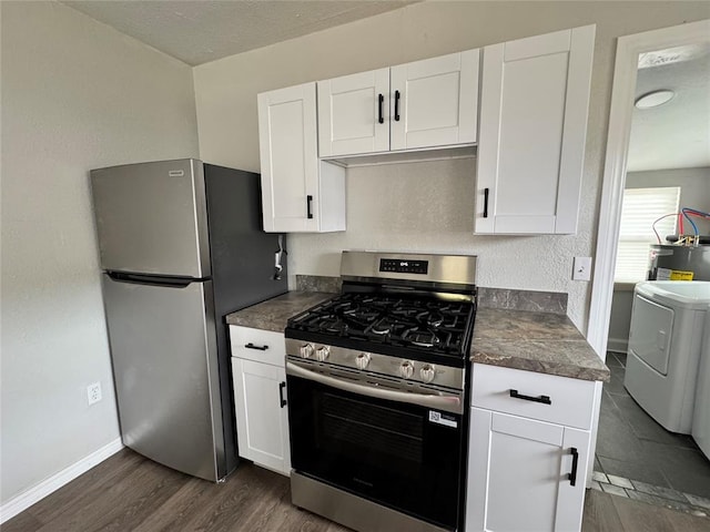 214 N 3rd St, Sentinel, OK 73664 - kitchen with appliances with stainless steel finishes, washer / dryer, dark countertops, white cabinetry, and a textured ceiling