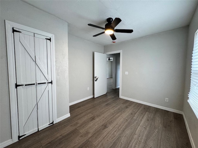 214 N 3rd St, Sentinel, OK 73664 - unfurnished bedroom with dark wood-style flooring, baseboards, and ceiling fan