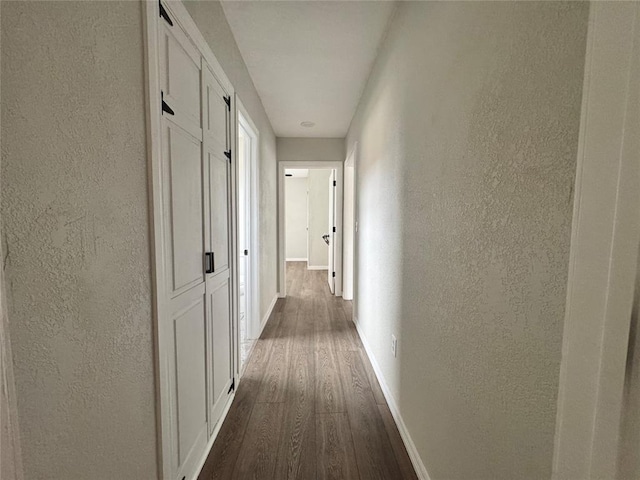 214 N 3rd St, Sentinel, OK 73664 - hallway with a textured wall, dark wood-type flooring, and baseboards