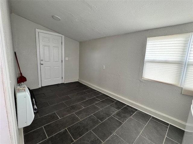 214 N 3rd St, Sentinel, OK 73664 - spare room featuring vaulted ceiling, a textured ceiling, and baseboards