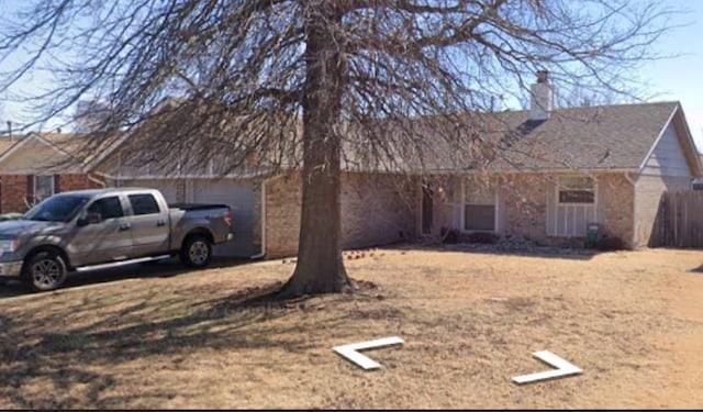 908 Linn Ln, Yukon, OK 73099 - view of front facade with a chimney, an attached garage, and brick siding