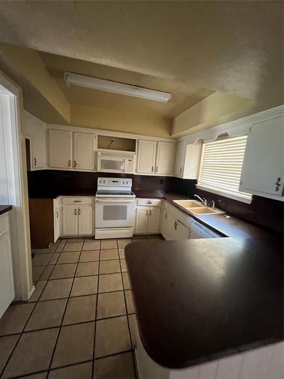 908 Linn Ln, Yukon, OK 73099 - kitchen with white appliances, a sink, white cabinetry, tile patterned floors, and dark countertops