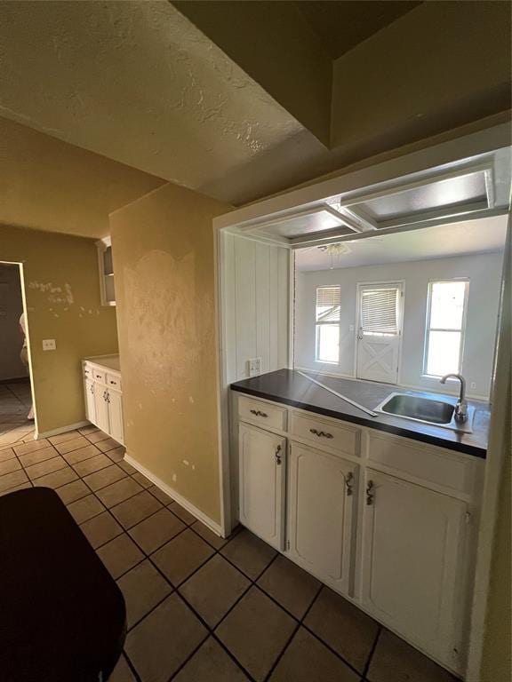908 Linn Ln, Yukon, OK 73099 - kitchen with a sink, light tile patterned floors, white cabinets, dark countertops, and baseboards