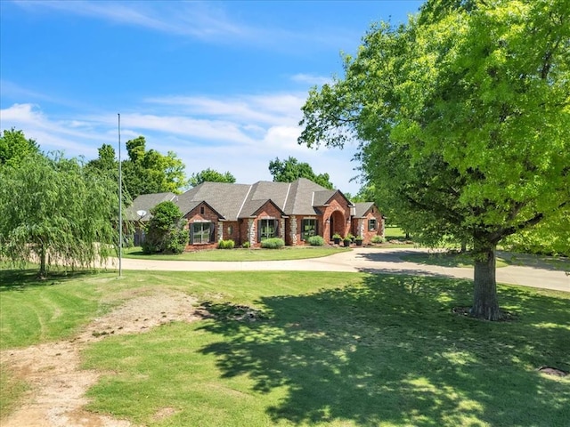 1322 Mockingbird Ln, Guthrie, OK 73044 - view of front facade featuring brick siding, a front yard, and curved driveway