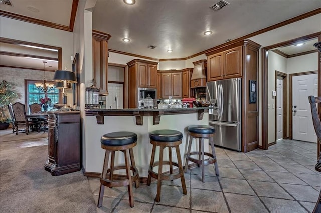 1322 Mockingbird Ln, Guthrie, OK 73044 - kitchen with appliances with stainless steel finishes, dark countertops, a breakfast bar area, crown molding, and a peninsula