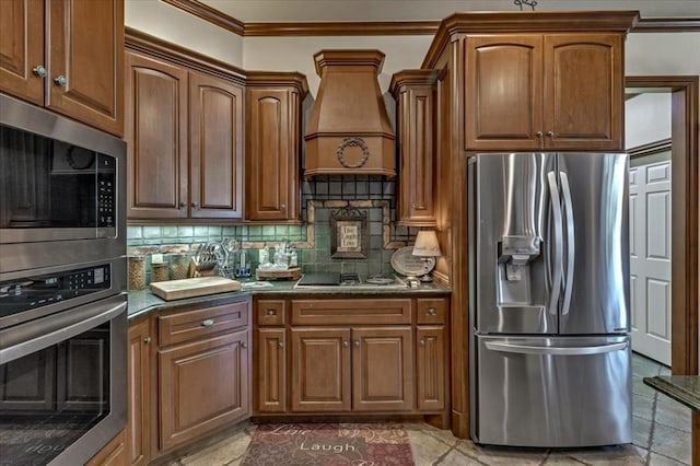1322 Mockingbird Ln, Guthrie, OK 73044 - kitchen featuring appliances with stainless steel finishes, premium range hood, decorative backsplash, crown molding, and brown cabinetry
