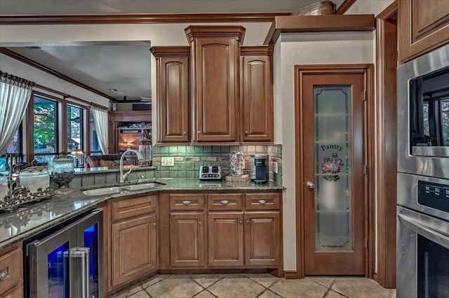 1322 Mockingbird Ln, Guthrie, OK 73044 - kitchen with beverage cooler, appliances with stainless steel finishes, a sink, crown molding, and stone counters