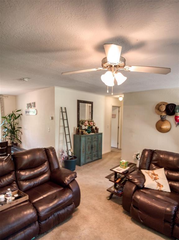 920245 S 3300th Rd, Wellston, OK 74881 - living area featuring a ceiling fan, carpet, and a textured ceiling