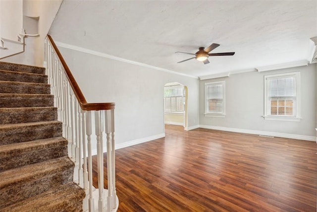 1535 NW 39th St, Oklahoma City, OK 73118 - unfurnished room featuring crown molding, a ceiling fan, wood finished floors, stairway, and arched walkways