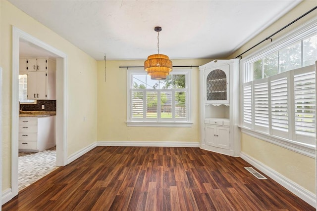 1535 NW 39th St, Oklahoma City, OK 73118 - unfurnished dining area featuring dark wood-style floors, plenty of natural light, a chandelier, and baseboards