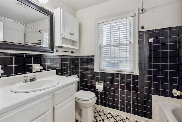 1535 NW 39th St, Oklahoma City, OK 73118 - full bathroom with tile walls, vanity, toilet, tile patterned floors, and wainscoting