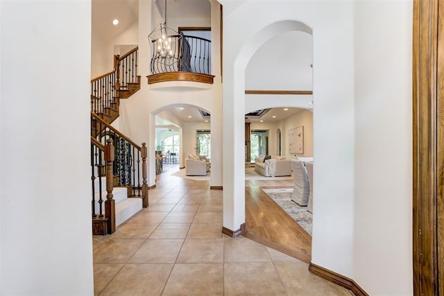 5905 Smoky Hill Trl, Edmond, OK 73034 - foyer featuring stairs, light tile patterned floors, arched walkways, a towering ceiling, and recessed lighting