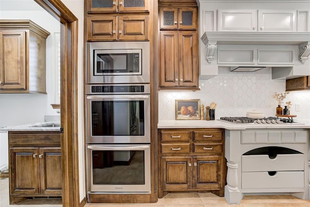 5905 Smoky Hill Trl, Edmond, OK 73034 - kitchen with stainless steel appliances, light countertops, and brown cabinetry