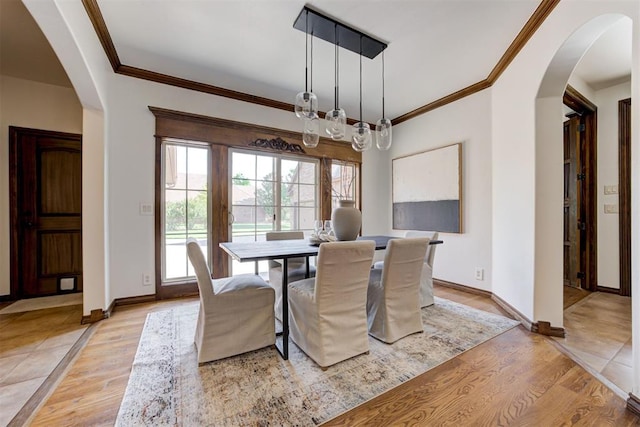 5905 Smoky Hill Trl, Edmond, OK 73034 - dining area with arched walkways, light wood-type flooring, baseboards, and crown molding