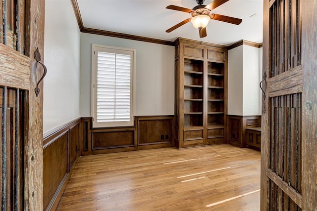 5905 Smoky Hill Trl, Edmond, OK 73034 - unfurnished living room with light wood-type flooring, ornamental molding, a ceiling fan, and wainscoting