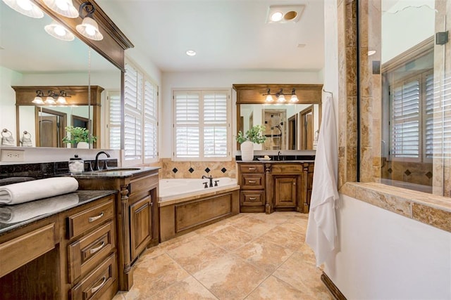 5905 Smoky Hill Trl, Edmond, OK 73034 - full bathroom featuring a bath, two vanities, a tile shower, and recessed lighting