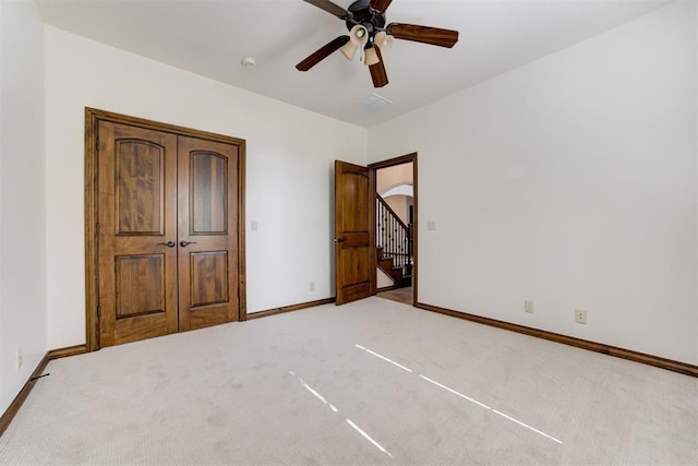 5905 Smoky Hill Trl, Edmond, OK 73034 - unfurnished bedroom with carpet, baseboards, arched walkways, and ceiling fan