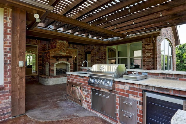 5905 Smoky Hill Trl, Edmond, OK 73034 - view of patio / terrace with beverage cooler, a sink, an outdoor brick fireplace, and a pergola