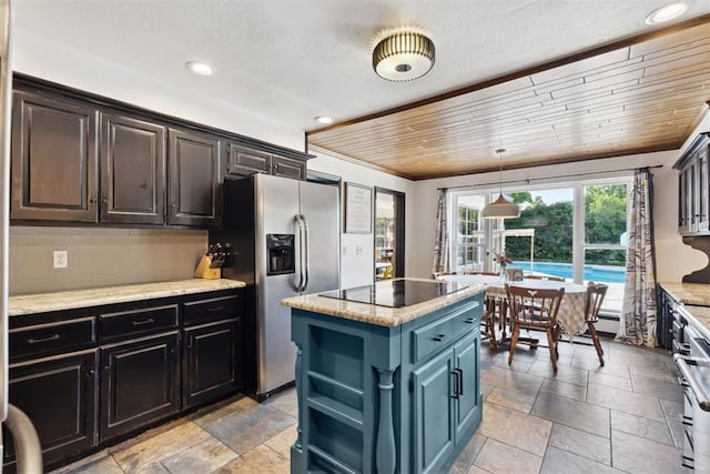 2208 Amber Rd, Oklahoma City, OK 73170 - kitchen with stainless steel fridge, black electric stovetop, a center island, stone tile flooring, and recessed lighting
