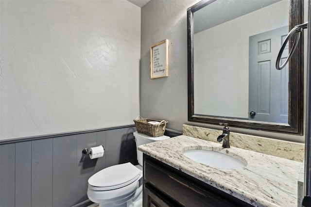 2208 Amber Rd, Oklahoma City, OK 73170 - bathroom featuring vanity, toilet, and a wainscoted wall