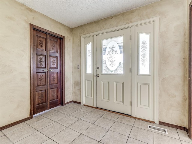 19005 Aerial Rd, Edmond, OK 73012 - foyer entrance featuring plenty of natural light, light tile patterned flooring, a textured ceiling, and baseboards