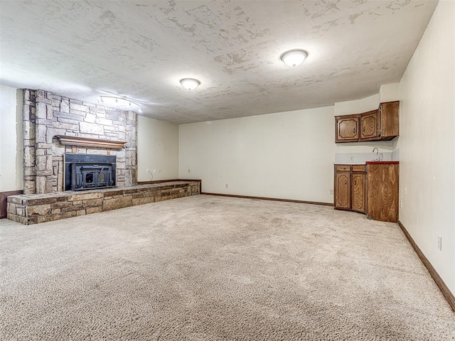 19005 Aerial Rd, Edmond, OK 73012 - unfurnished living room with light carpet, a stone fireplace, and baseboards