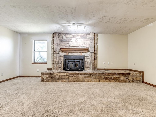 19005 Aerial Rd, Edmond, OK 73012 - unfurnished living room featuring carpet floors, a stone fireplace, and baseboards