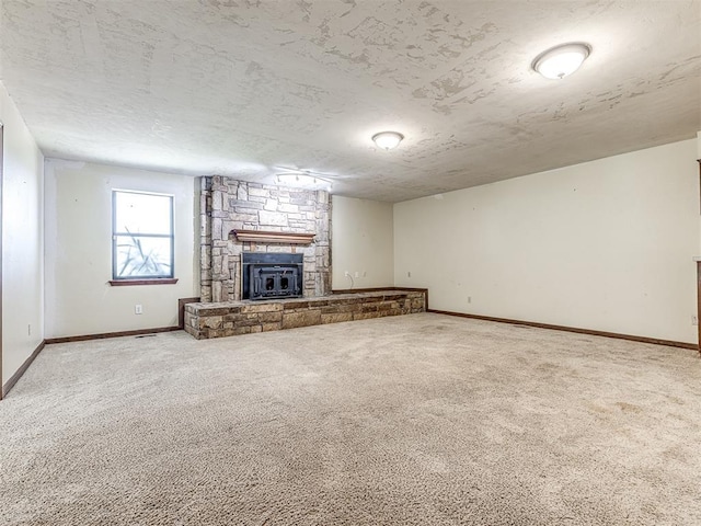 19005 Aerial Rd, Edmond, OK 73012 - unfurnished living room featuring carpet flooring, a stone fireplace, baseboards, and a textured ceiling
