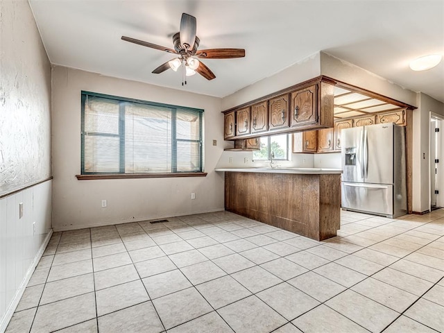 19005 Aerial Rd, Edmond, OK 73012 - kitchen featuring stainless steel fridge, a peninsula, ceiling fan, light tile patterned floors, and light countertops