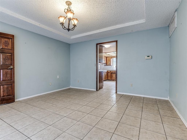 19005 Aerial Rd, Edmond, OK 73012 - unfurnished room featuring a textured ceiling, a tray ceiling, light tile patterned flooring, a chandelier, and baseboards