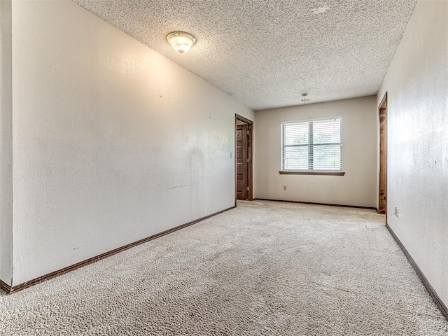 19005 Aerial Rd, Edmond, OK 73012 - spare room featuring carpet floors, a textured ceiling, baseboards, and a textured wall