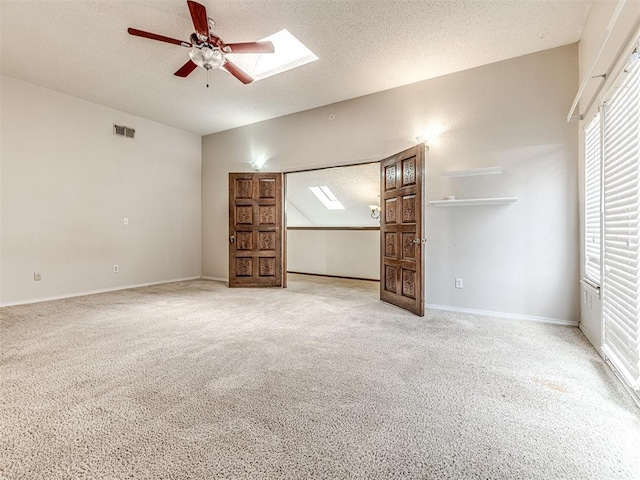 19005 Aerial Rd, Edmond, OK 73012 - unfurnished living room with ceiling fan, carpet, a textured ceiling, a skylight, and baseboards