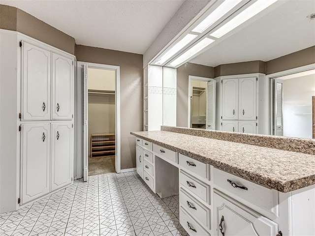 19005 Aerial Rd, Edmond, OK 73012 - bathroom featuring vanity, a walk in closet, and baseboards