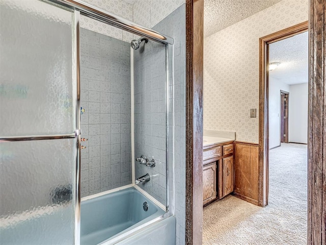 19005 Aerial Rd, Edmond, OK 73012 - full bathroom with wallpapered walls, shower / bath combination with glass door, vanity, a textured ceiling, and wainscoting