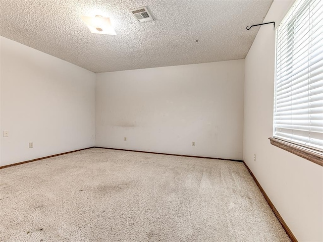 19005 Aerial Rd, Edmond, OK 73012 - carpeted empty room featuring healthy amount of natural light, a textured ceiling, and baseboards