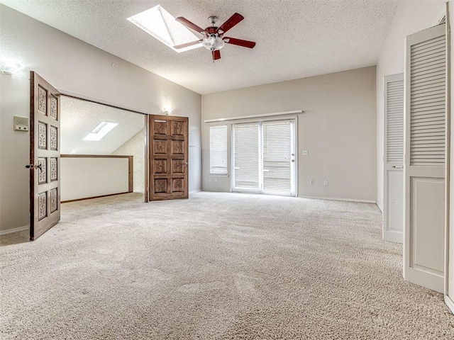 19005 Aerial Rd, Edmond, OK 73012 - unfurnished bedroom featuring a skylight, a textured ceiling, vaulted ceiling, carpet flooring, and ceiling fan
