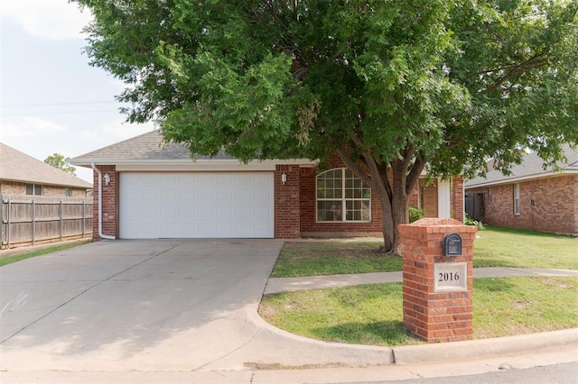 2016 NW 172nd St, Edmond, OK 73012 - view of property hidden behind natural elements with brick siding, driveway, an attached garage, and roof with shingles