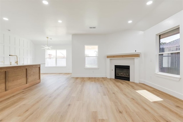 2016 NW 172nd St, Edmond, OK 73012 - unfurnished living room featuring a fireplace, light wood-style flooring, a sink, baseboards, and recessed lighting