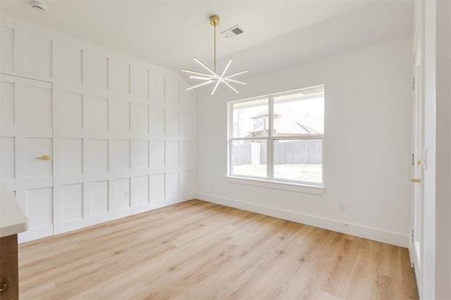 2016 NW 172nd St, Edmond, OK 73012 - unfurnished dining area featuring light wood-type flooring, baseboards, and a chandelier