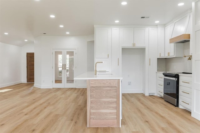 2016 NW 172nd St, Edmond, OK 73012 - kitchen featuring stainless steel electric range oven, custom exhaust hood, recessed lighting, light wood-type flooring, and white cabinets