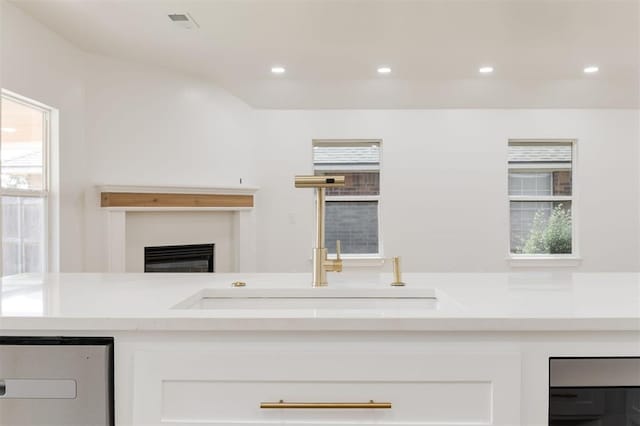 2016 NW 172nd St, Edmond, OK 73012 - kitchen featuring white cabinetry, light countertops, a glass covered fireplace, and recessed lighting