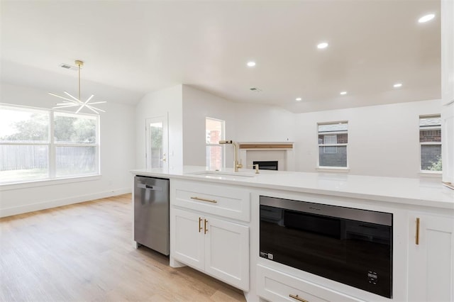 2016 NW 172nd St, Edmond, OK 73012 - kitchen with appliances with stainless steel finishes, a sink, light countertops, white cabinets, and a fireplace