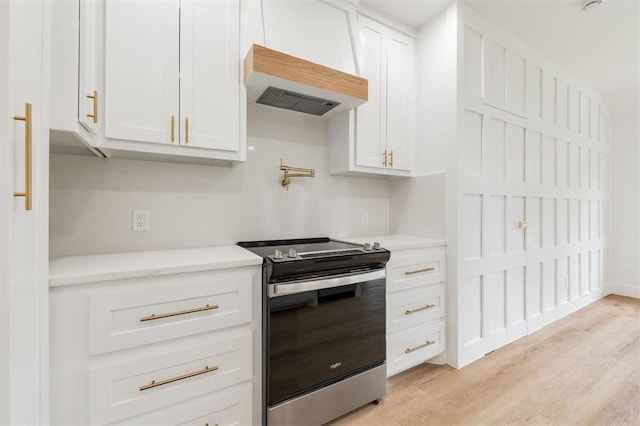 2016 NW 172nd St, Edmond, OK 73012 - kitchen with stainless steel electric range, custom exhaust hood, light countertops, white cabinets, and light wood-type flooring