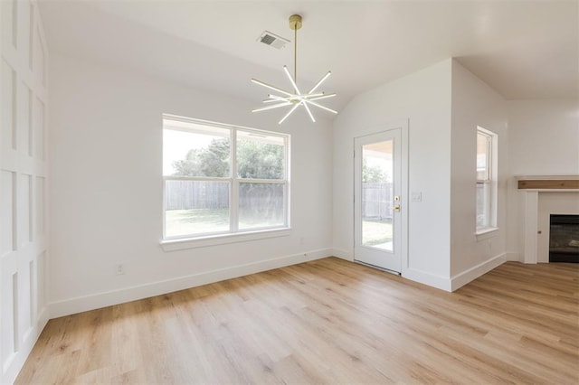 2016 NW 172nd St, Edmond, OK 73012 - unfurnished living room with light wood-type flooring, a fireplace, baseboards, vaulted ceiling, and a chandelier